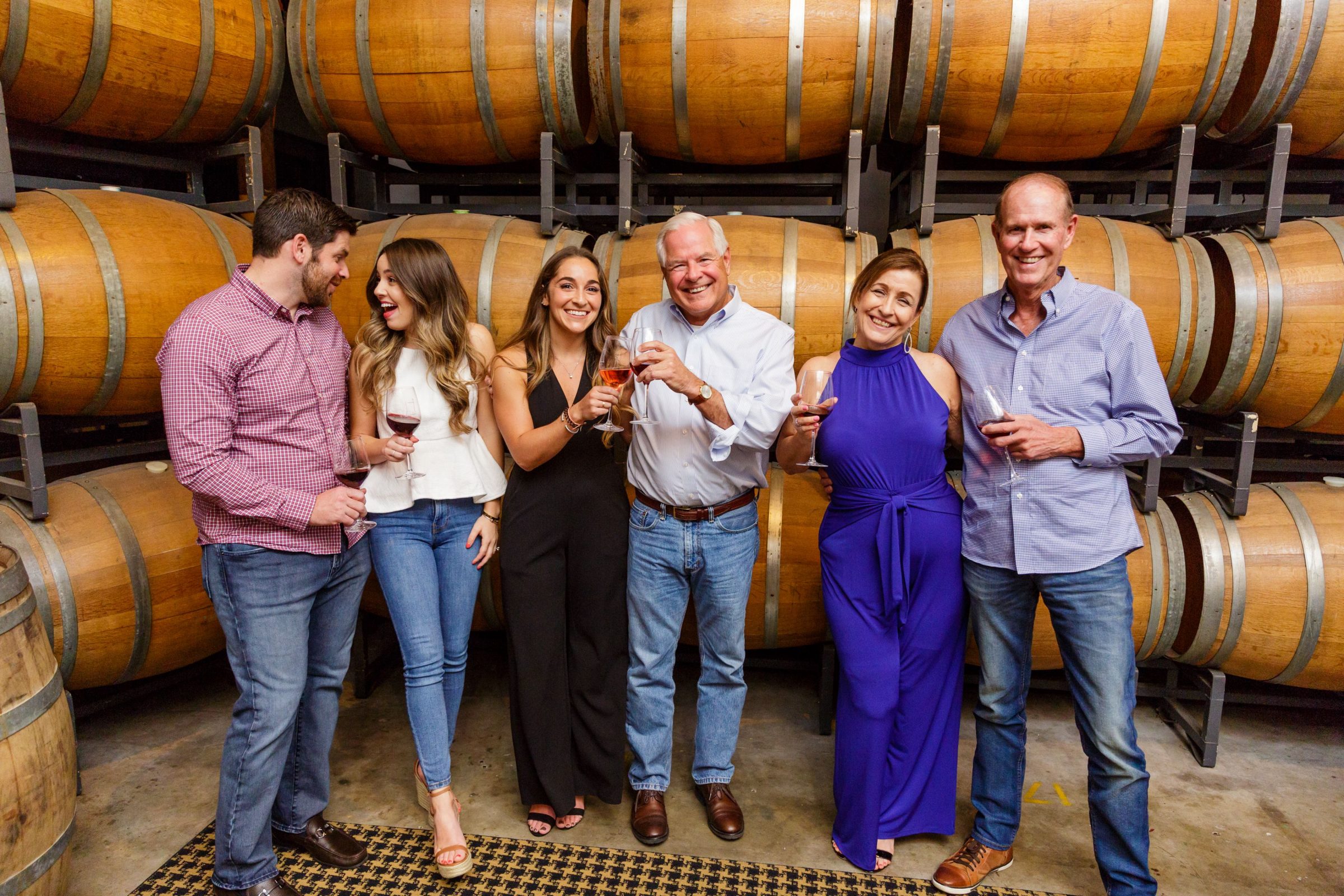 Three couples in front of wine casks